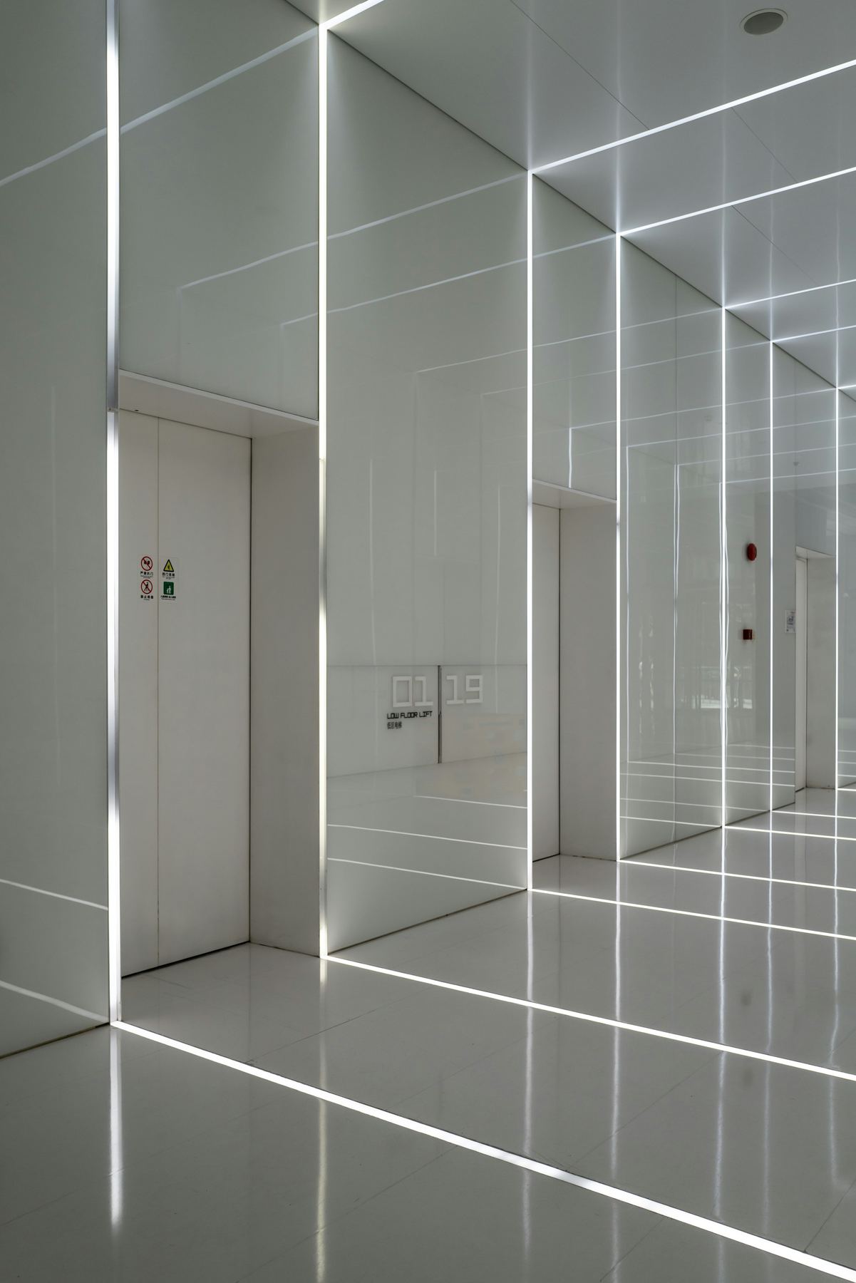 Bright, clean modern building corridor leading to an elevator door