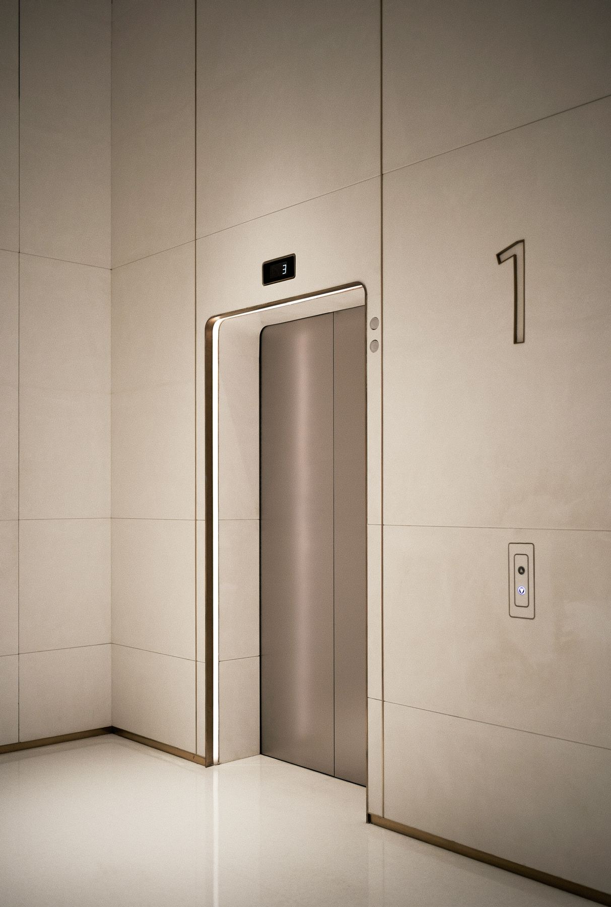 Elegant elevator door with marble surround and a floor-3 indicator in a premium lobby