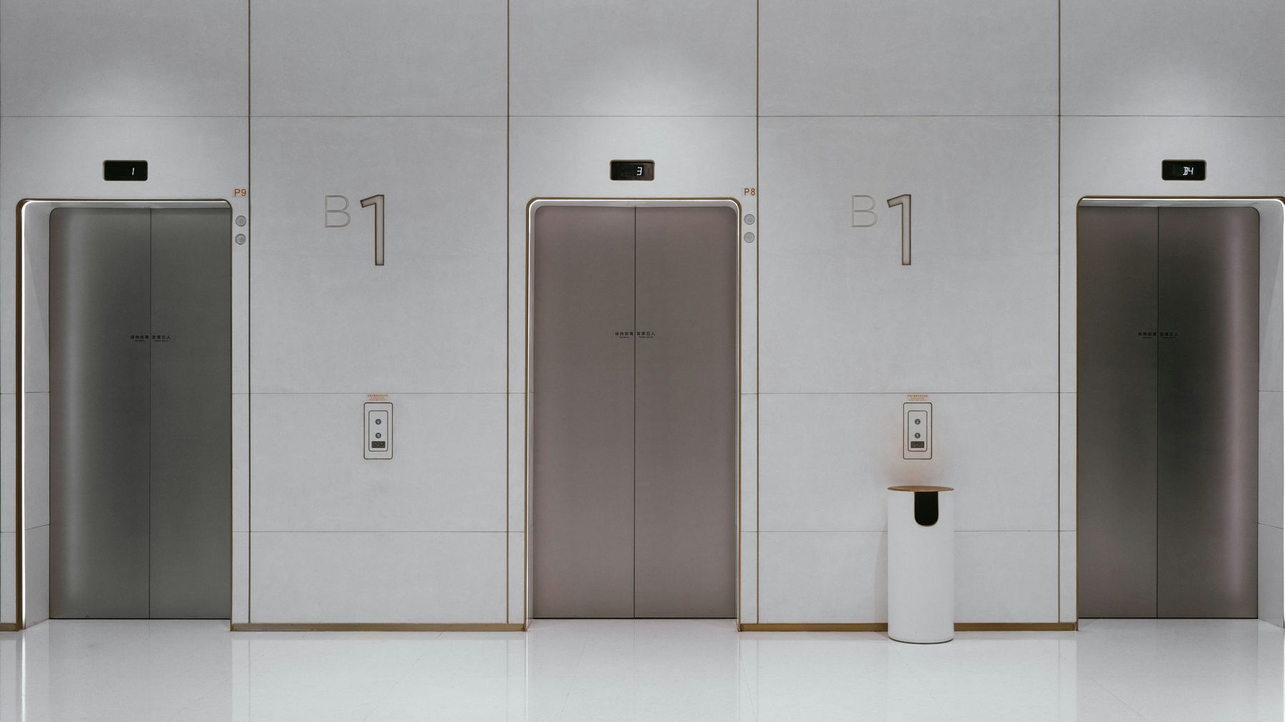 Modern elevator lobby with a bank of passenger elevators and floor indicators