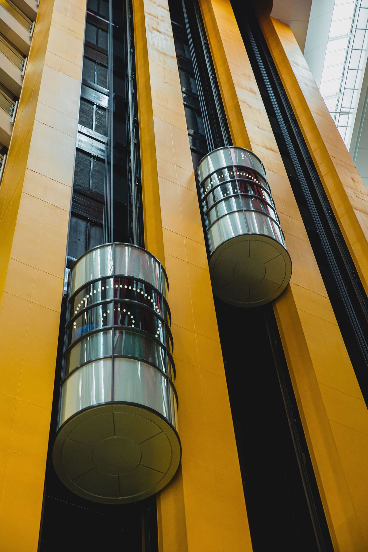 Distinctive round observation elevator pods on a bright yellow architectural shaft