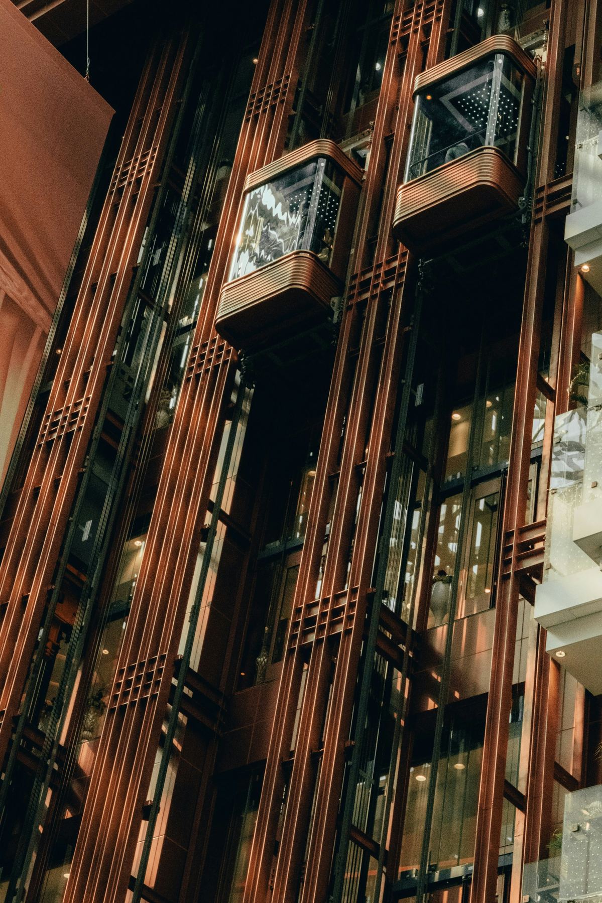 Modernized glass and bronze-finish elevator shafts in a building atrium