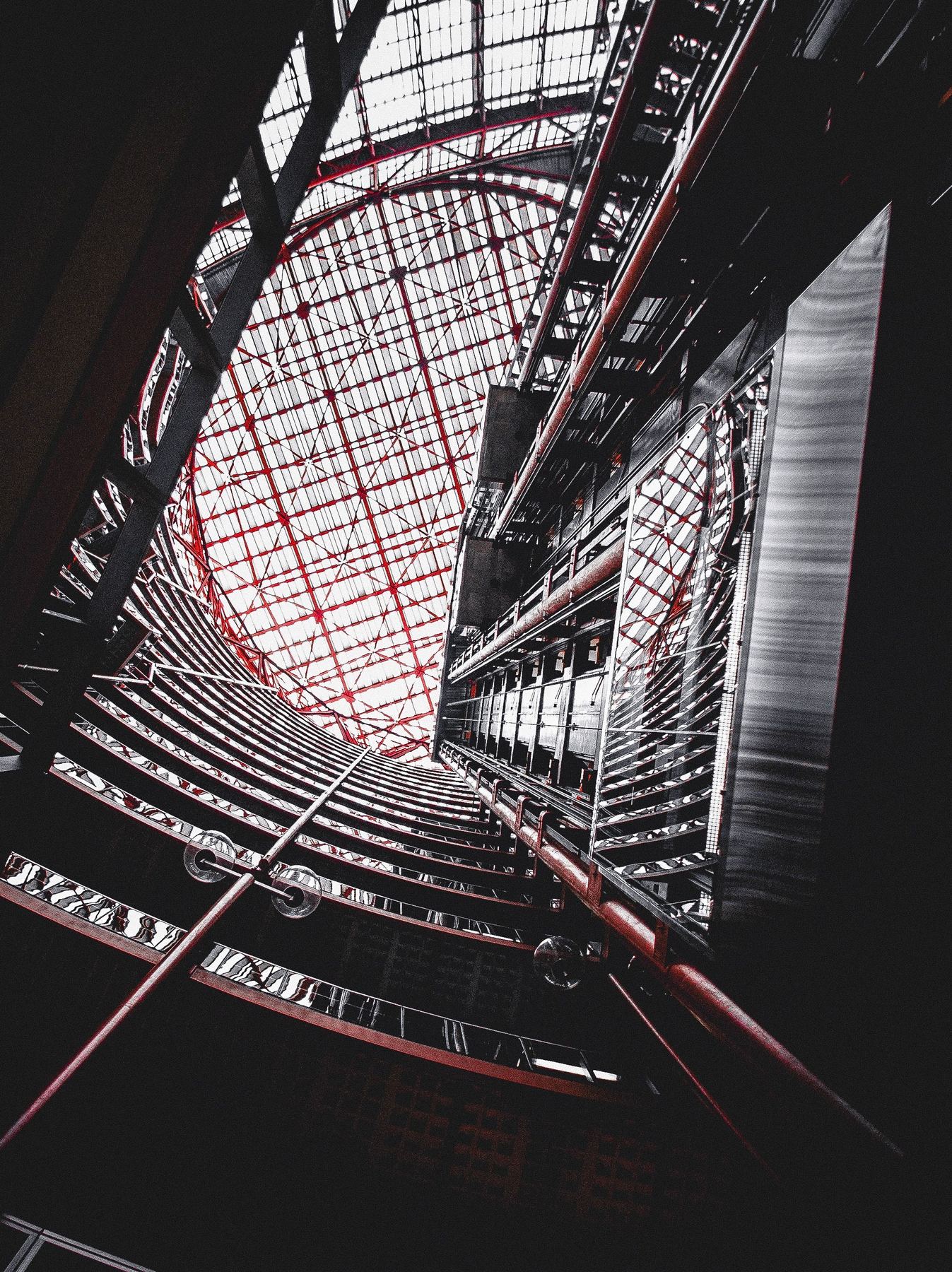 Abstract upward view of an elevator shaft with a red wireframe lattice structure, evoking a connected sensor network